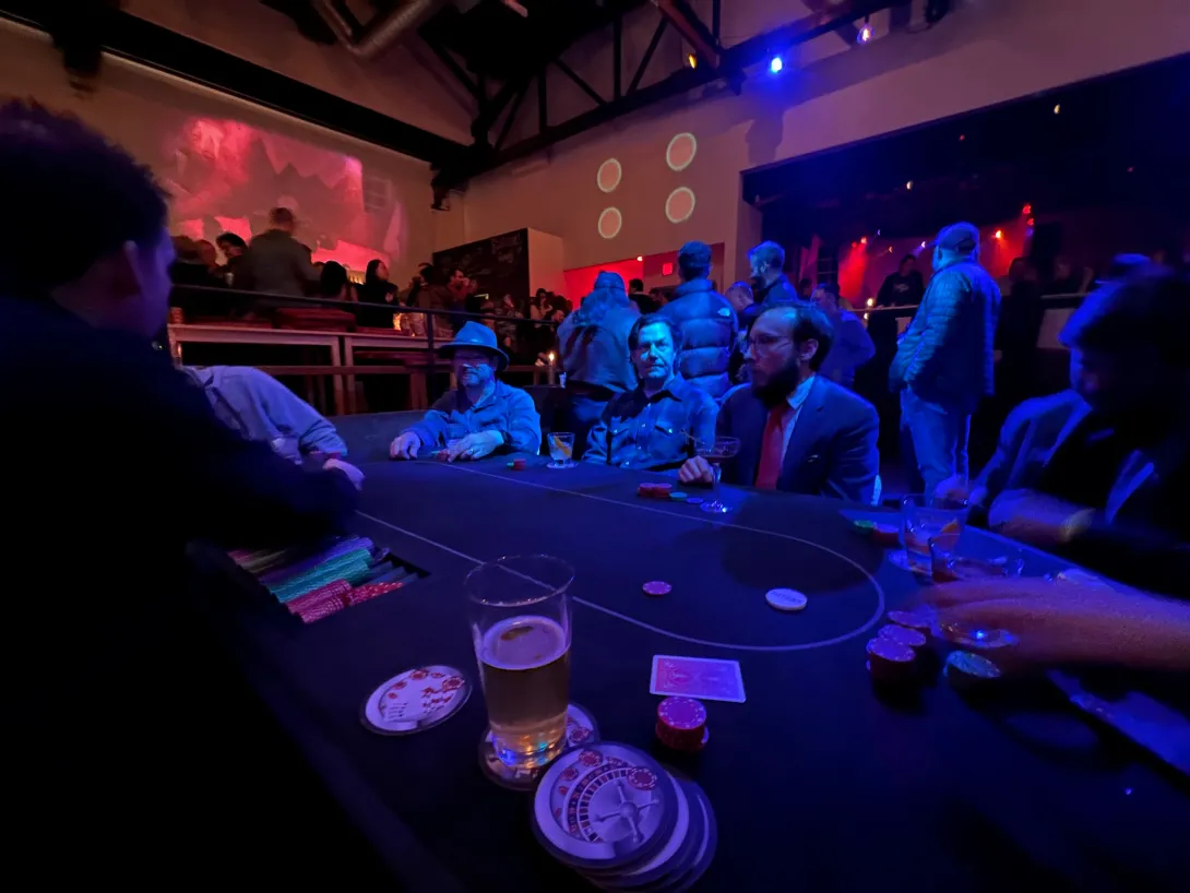 View from a poker table showing a full table with little chips, and a glass of beer