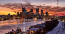 View of Pittsburgh with the river reflecting the sunset behind the skyline