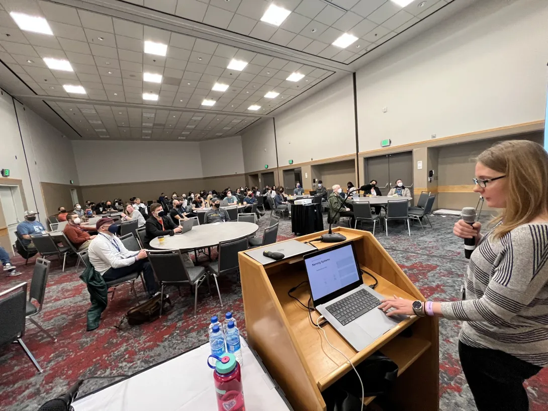 Jen presenting in front of a room full of people