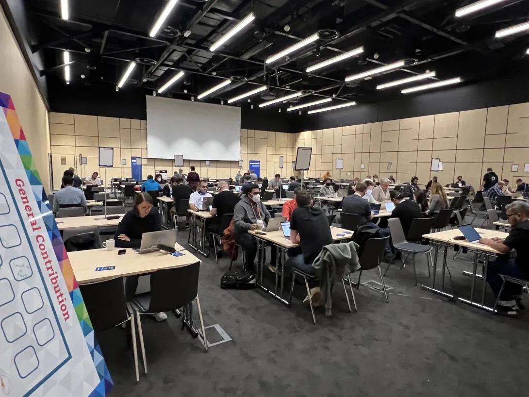 View of the contribution room with people sitting around various tables working