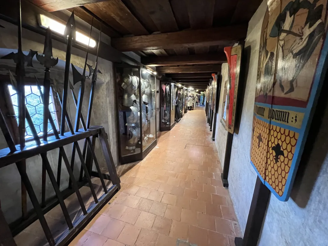Looking down a hallway in the golden lane with medieval weapons on both sides