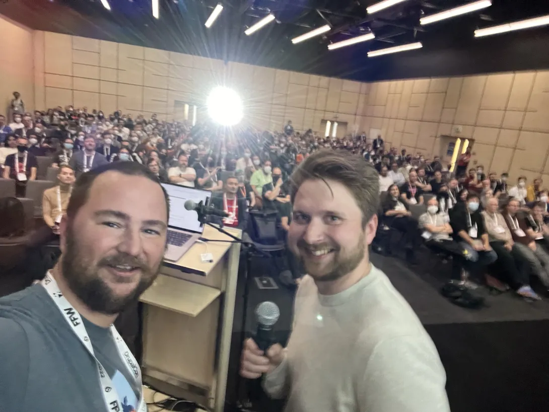 Selfie of Mike and Lauri in front of a lectern in front of a packed room