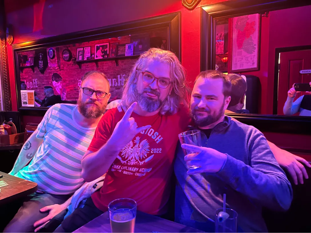 3 drunk people making faces in back of a karaoke bar