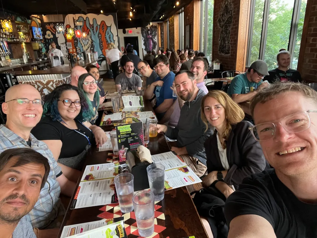 A selfie taken from the end of the table showing lots of smiling faces