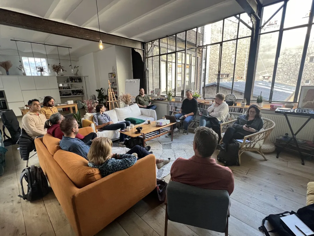 Drupal Board of Directors members sitting around a cozy loft with a big window, couches, etc