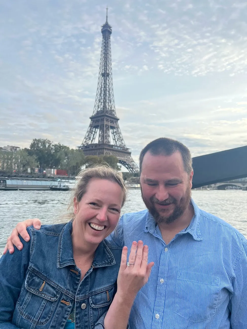 Robin and I in front of the Eiffel Tower with Robin smiling and showing off her new engagement ring
