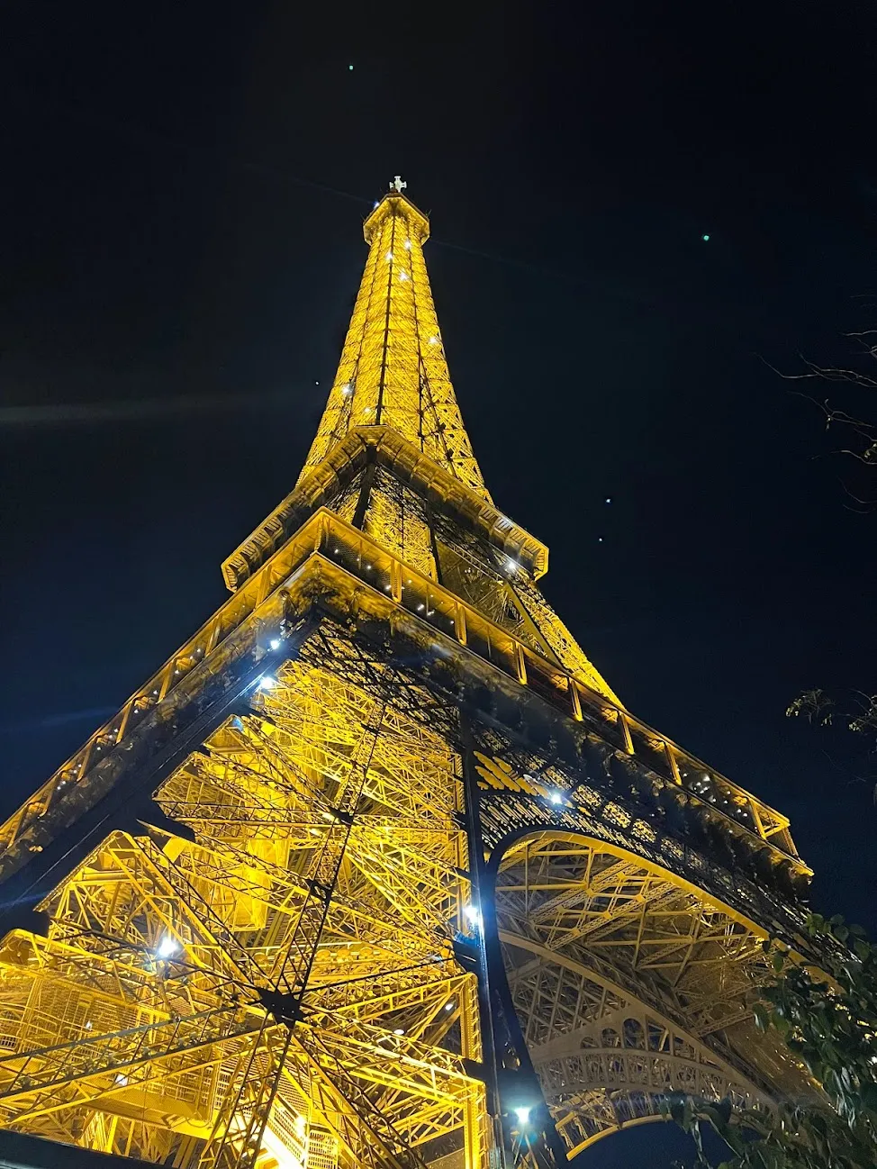 Eiffel Tower lit up at night from the very bottom